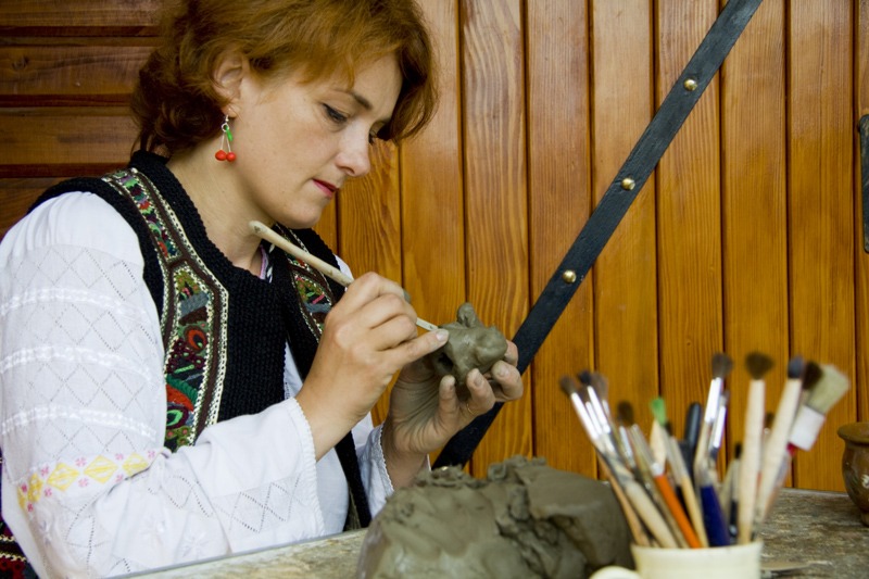 Mesterul popular Ionela Lungu picteaza o figurina de lut