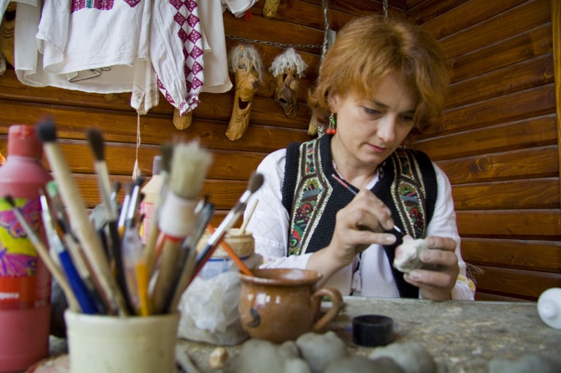 Mesterul popular Ionela Lungu picteaza o figurina de lut