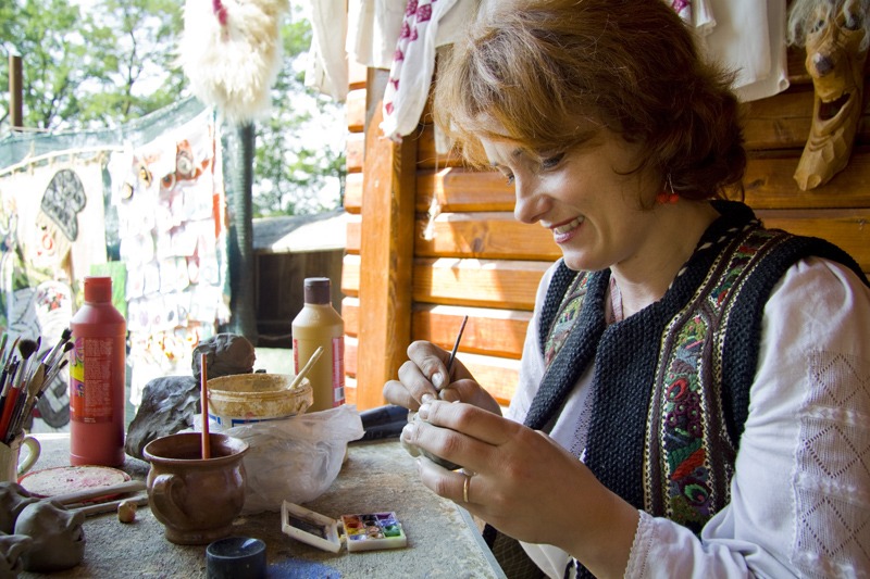 Mesterul popular Ionela Lungu picteaza o figurina de lut